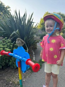 Young girl with fledgling bird perched on handlebar , by Sophie Bailey